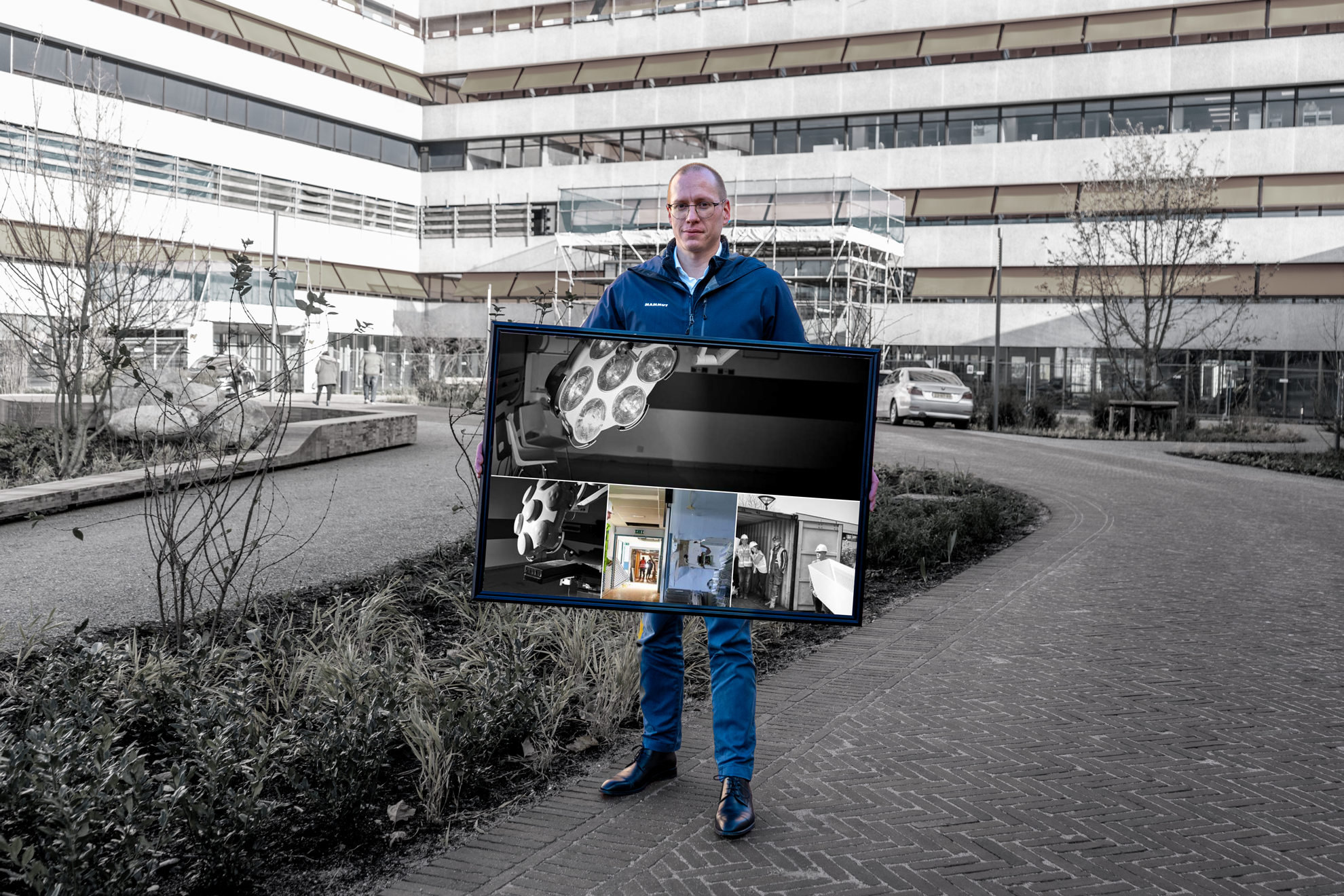 Een man staat met een fotolijst in zijn handen. 